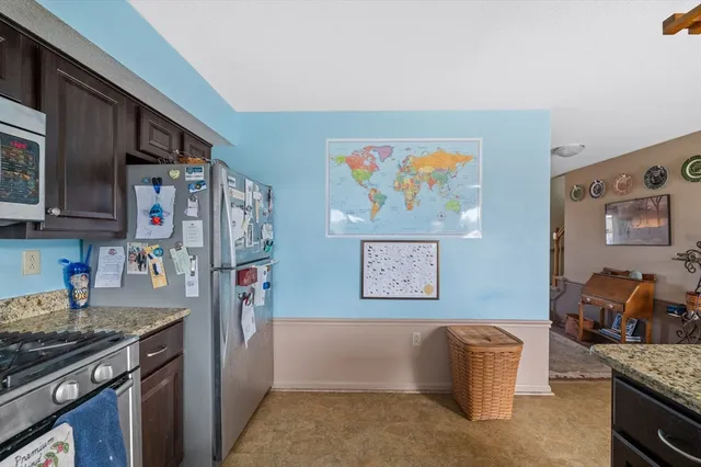 a kitchen with stainless steel appliances granite countertop a refrigerator and a stove top oven