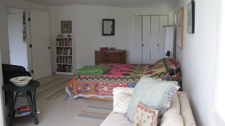 63 Old County Road Truro, MA 02666 - Photo 14 of 30 a bedroom with a bed and a chandelier