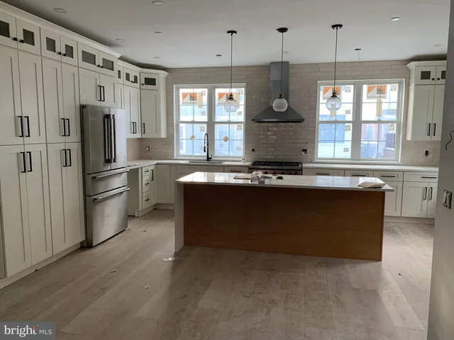 a kitchen with stainless steel appliances a stove cabinets and a window