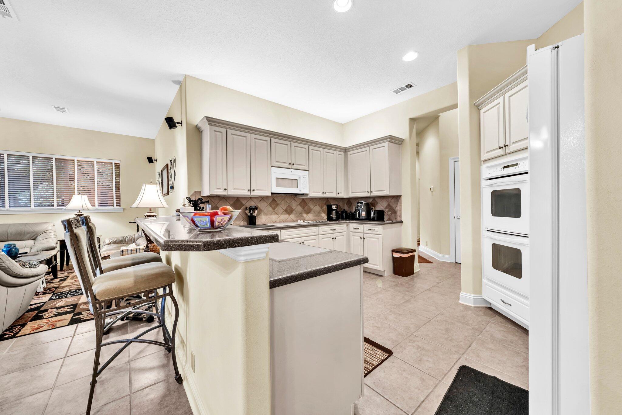 423 Maritime Court Destin, FL 32541 - Photo 17 of 39 a kitchen with white cabinets and stainless steel appliances