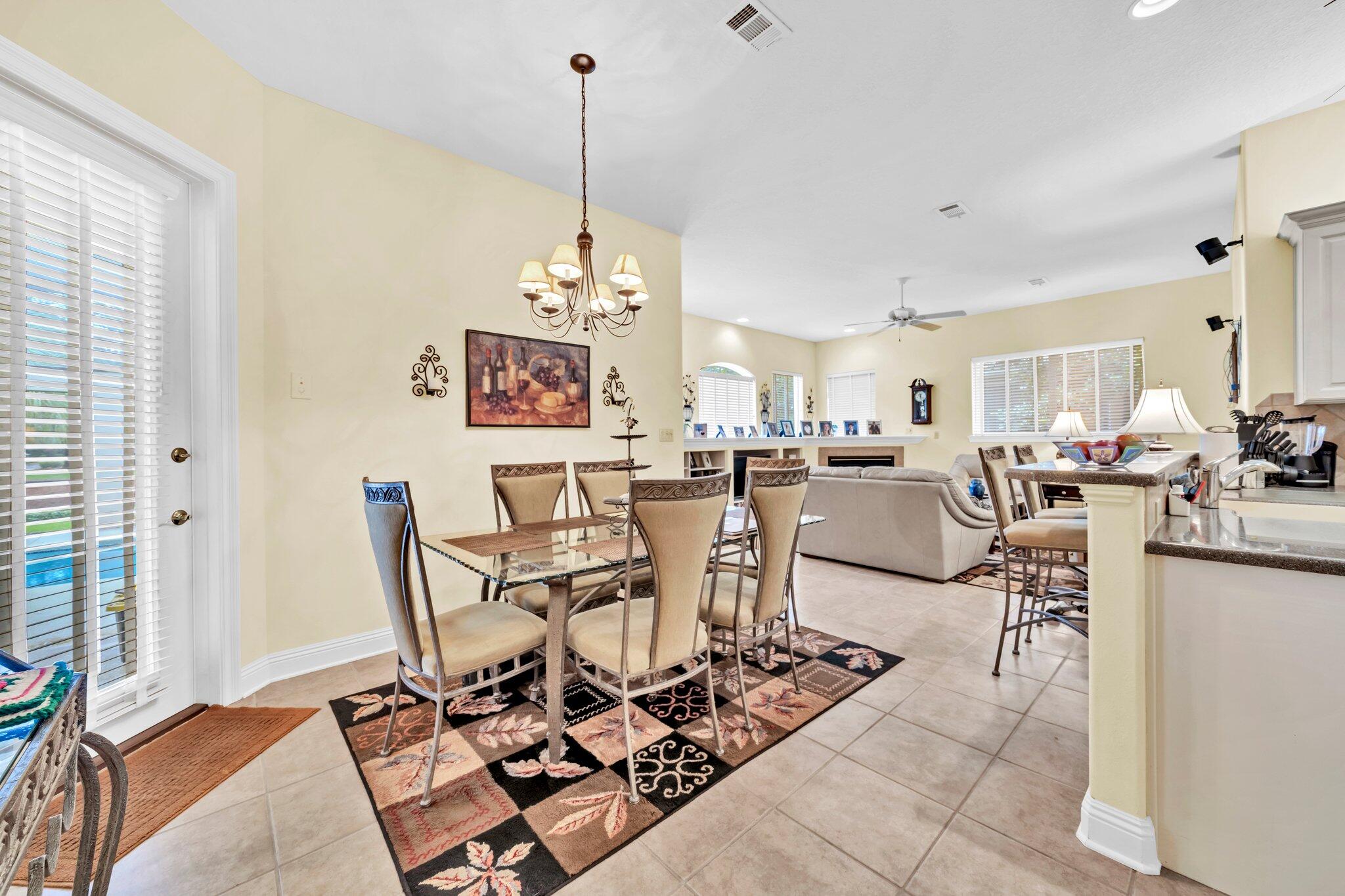 423 Maritime Court Destin, FL 32541 - Photo 20 of 39 a view of a dining room and livingroom with furniture wooden floor a rug a painting and a chandelier