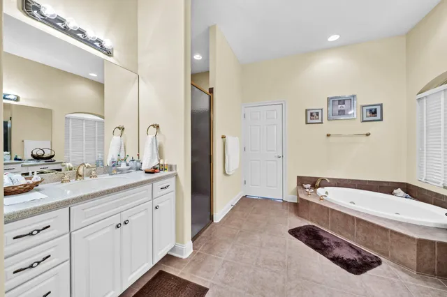 a spacious bathroom with a granite countertop tub sink and mirror