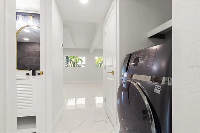 a kitchen with stainless steel appliances kitchen island granite countertop a refrigerator and a sink