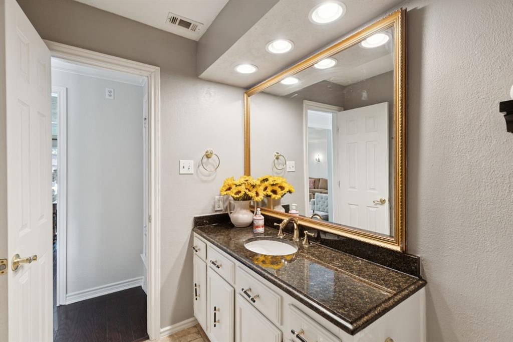 9315 Moss Cir Drive Dallas, TX 75243 - Photo 29 of 36 a bathroom with a granite countertop sink a mirror and a shower