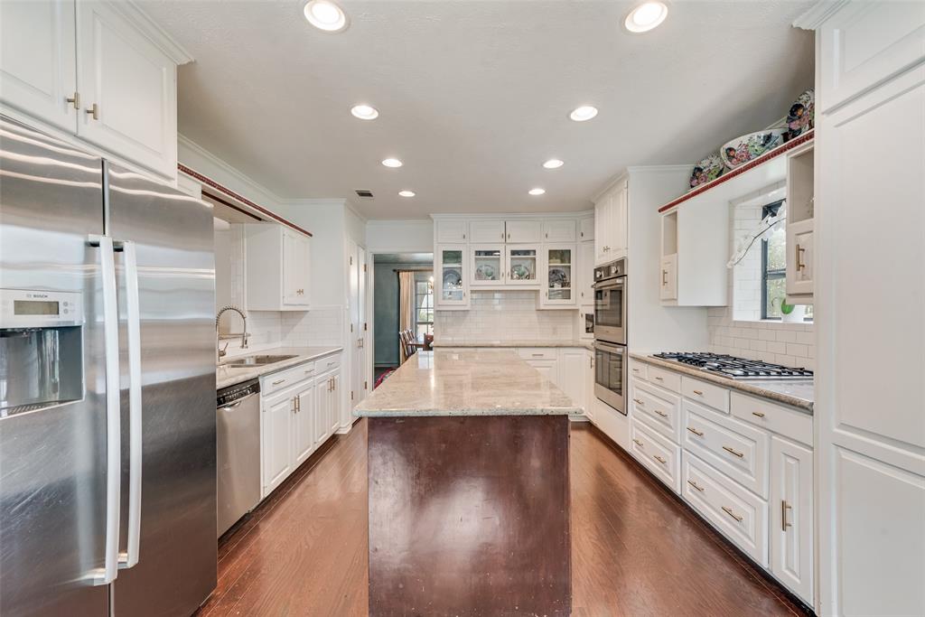 9315 Moss Cir Drive Dallas, TX 75243 - Photo 9 of 36 a large kitchen with stainless steel appliances granite countertop a large counter top a stove and a refrigerator