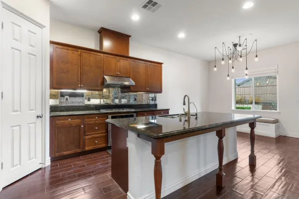 a kitchen with stainless steel appliances granite countertop a sink and stove