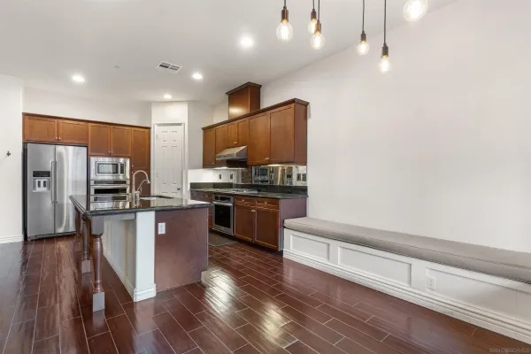 a kitchen with stainless steel appliances kitchen island granite countertop a refrigerator and a stove top oven