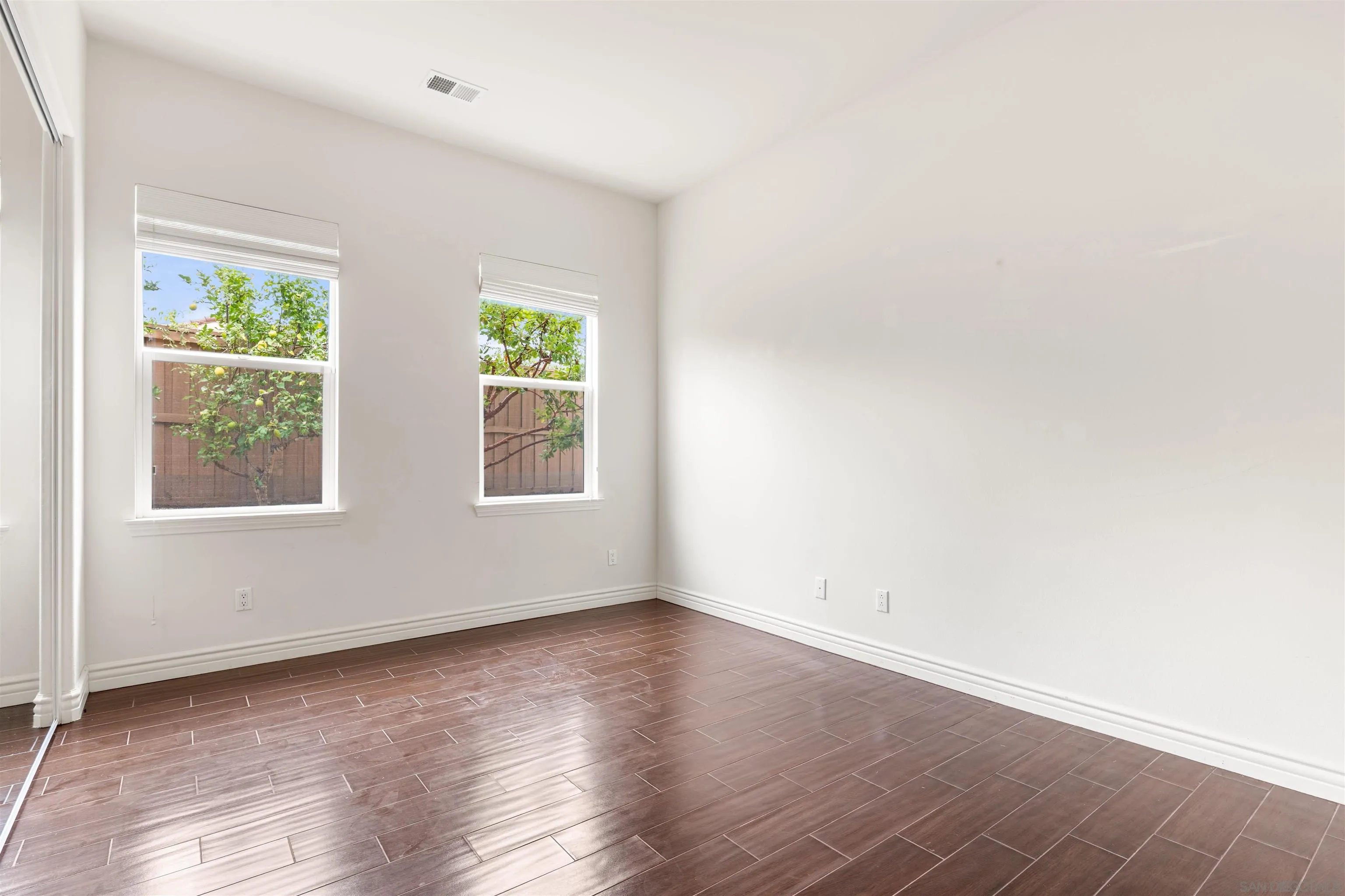 2067 James Gaynor Street Fallbrook, CA 92028 - Photo 19 of 33 an empty room with wooden floor and windows