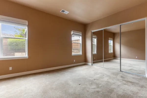 an empty room with windows and closet