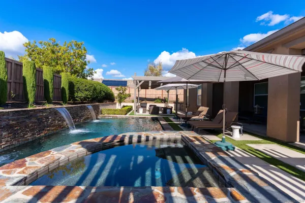 a view of a patio with couches table and chairs under an umbrella