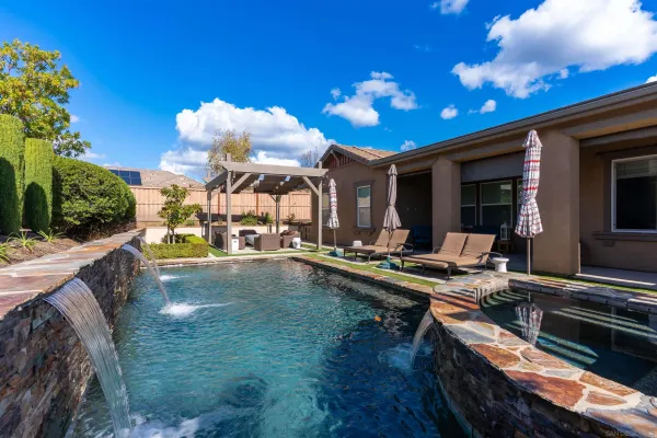 a view of a house with swimming pool and sitting area