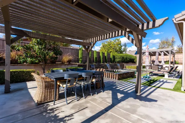 a view of a patio with a dining table and chairs with wooden floor