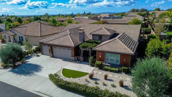 an aerial view of a house with yard and patio
