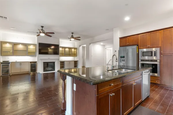 a kitchen with stainless steel appliances granite countertop a sink a stove and a wooden floors