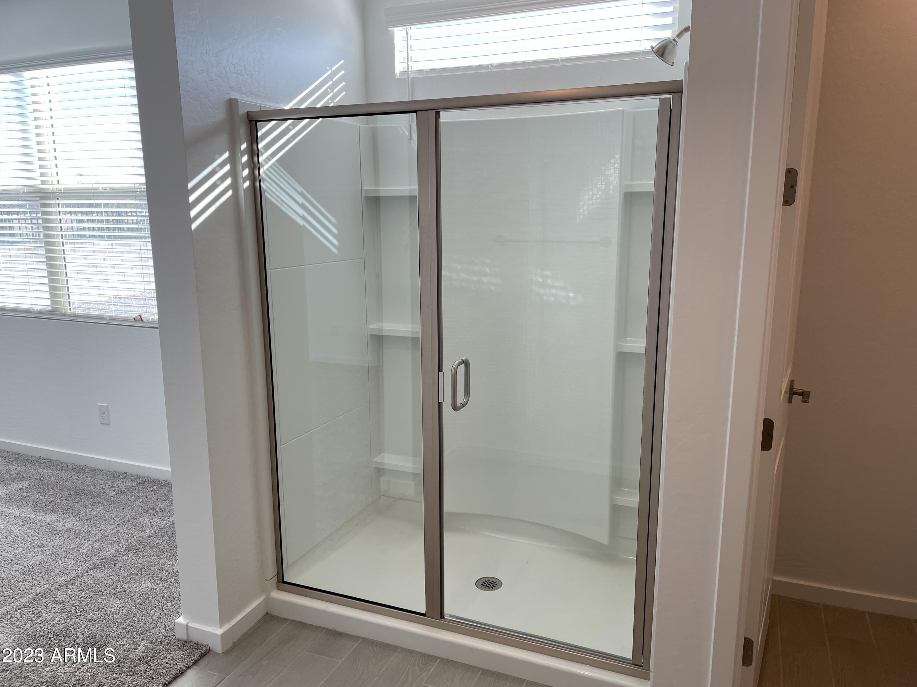 17401 West Red Fox Road Surprise, AZ 85387 - Photo 13 of 41 a bathroom with a glass shower door