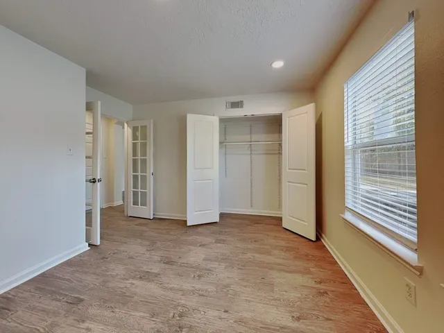 a view of an empty room with wooden floor