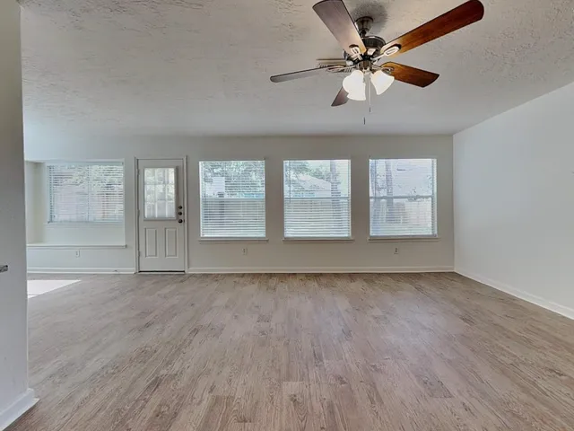 a kitchen with stainless steel appliances granite countertop a stove top oven a sink a refrigerator and white cabinets