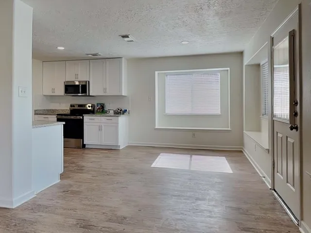 a kitchen with white cabinets and stainless steel appliances
