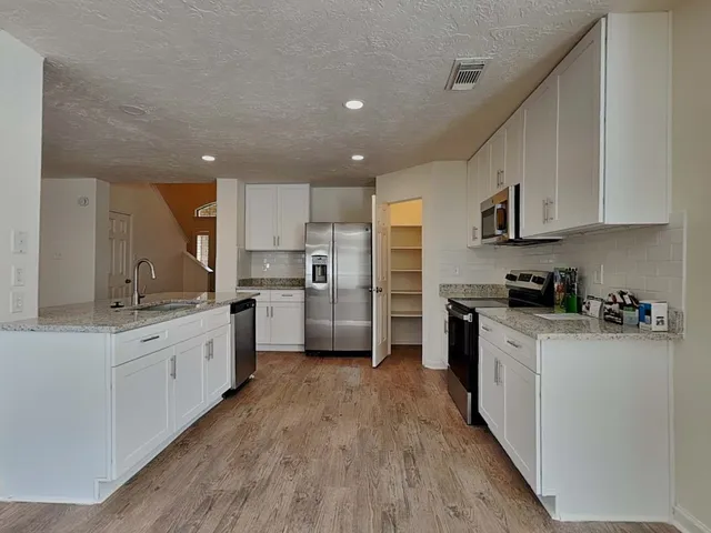 a view of an empty room with window a ceiling fan and wooden floor