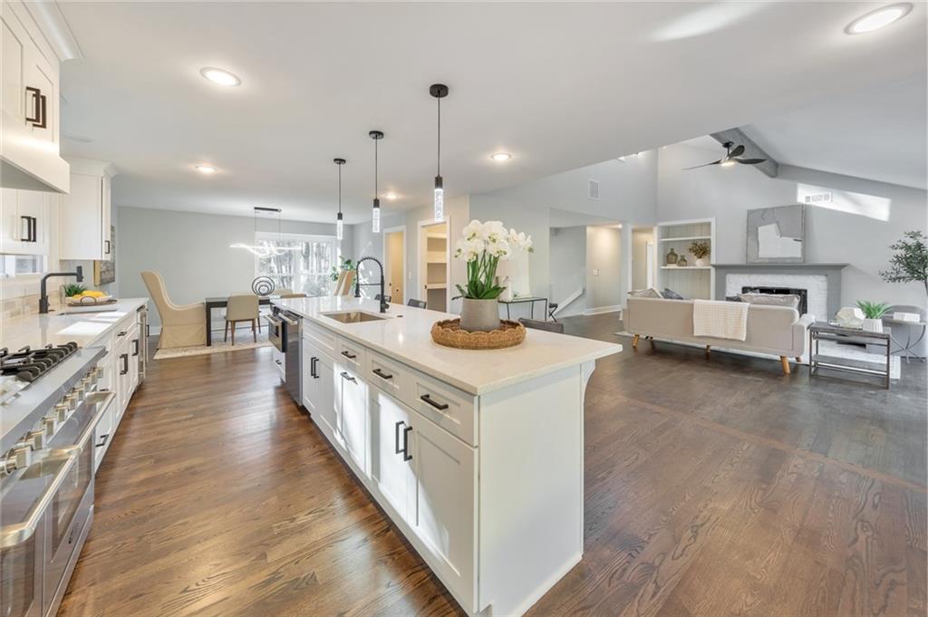 2066 Old Forge Way Marietta, GA 30068 - Photo 15 of 54 a large kitchen with stainless steel appliances kitchen island a large counter top a sink a stove and a wooden floors