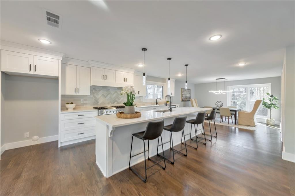 2066 Old Forge Way Marietta, GA 30068 - Photo 2 of 54 a kitchen with a dining table chairs stove and white cabinets