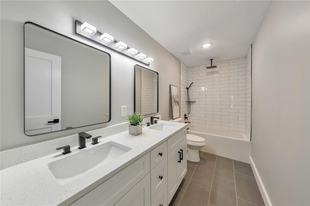 2066 Old Forge Way Marietta, GA 30068 - Photo 28 of 54 a bathroom with a double vanity sink a toilet and a large mirror