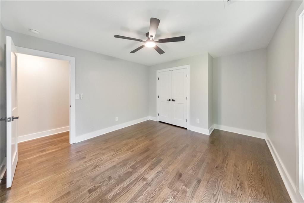 2066 Old Forge Way Marietta, GA 30068 - Photo 30 of 54 an empty room with wooden floor a ceiling fan and windows