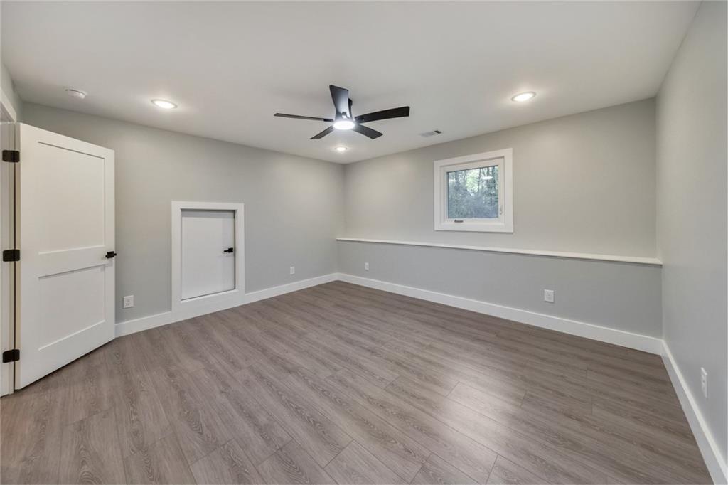 2066 Old Forge Way Marietta, GA 30068 - Photo 35 of 54 an empty room with wooden floor ceiling fan and windows