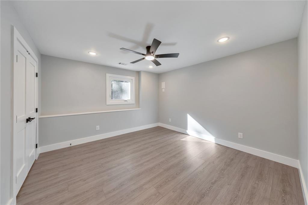 2066 Old Forge Way Marietta, GA 30068 - Photo 38 of 54 an empty room with wooden floor ceiling fan and windows