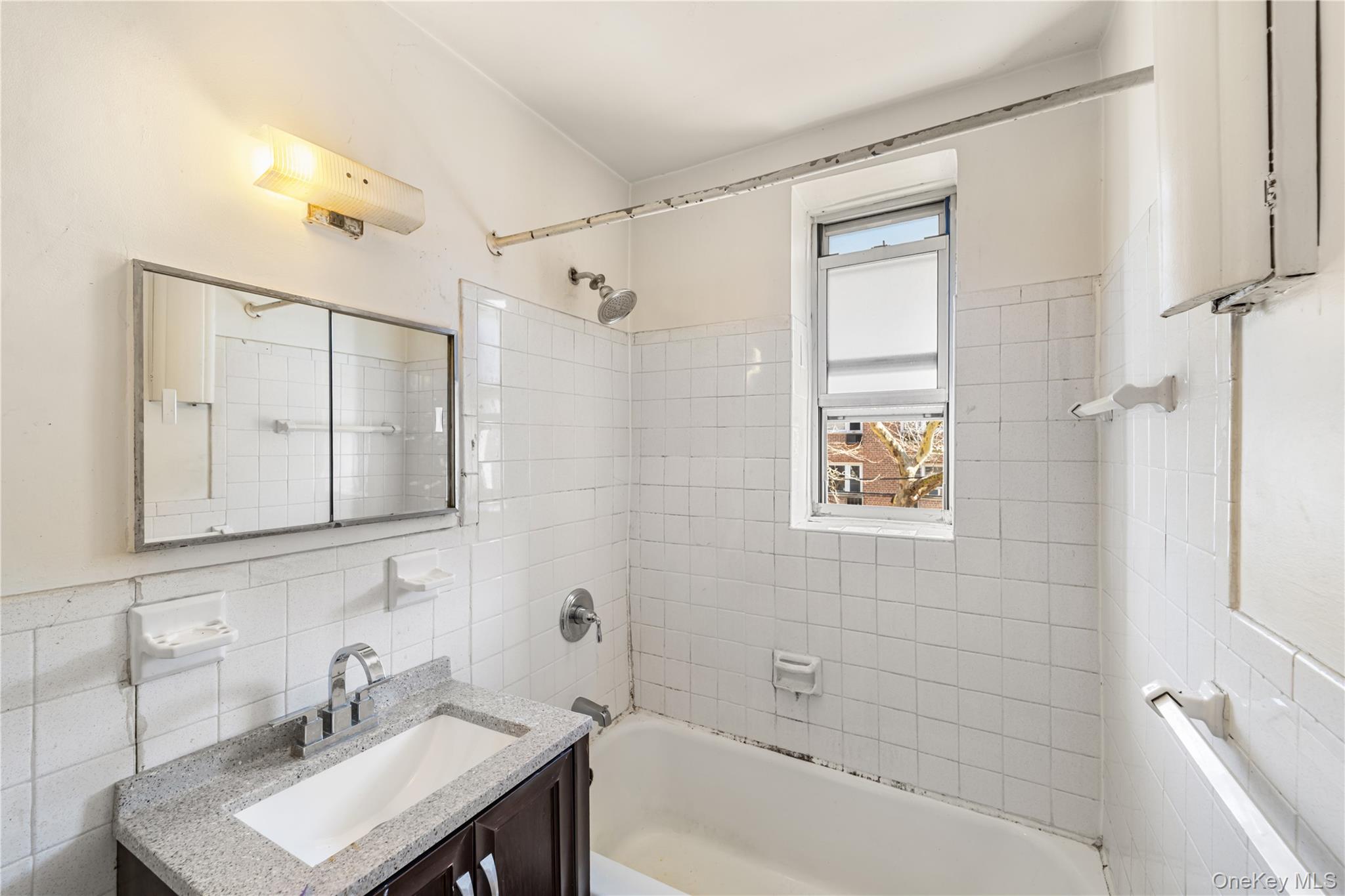 600 Locust Street, Unit 3G Mount Vernon, NY 10552 - Photo 21 of 25 a bathroom with a bathtub a sink a mirror a vanity and shower