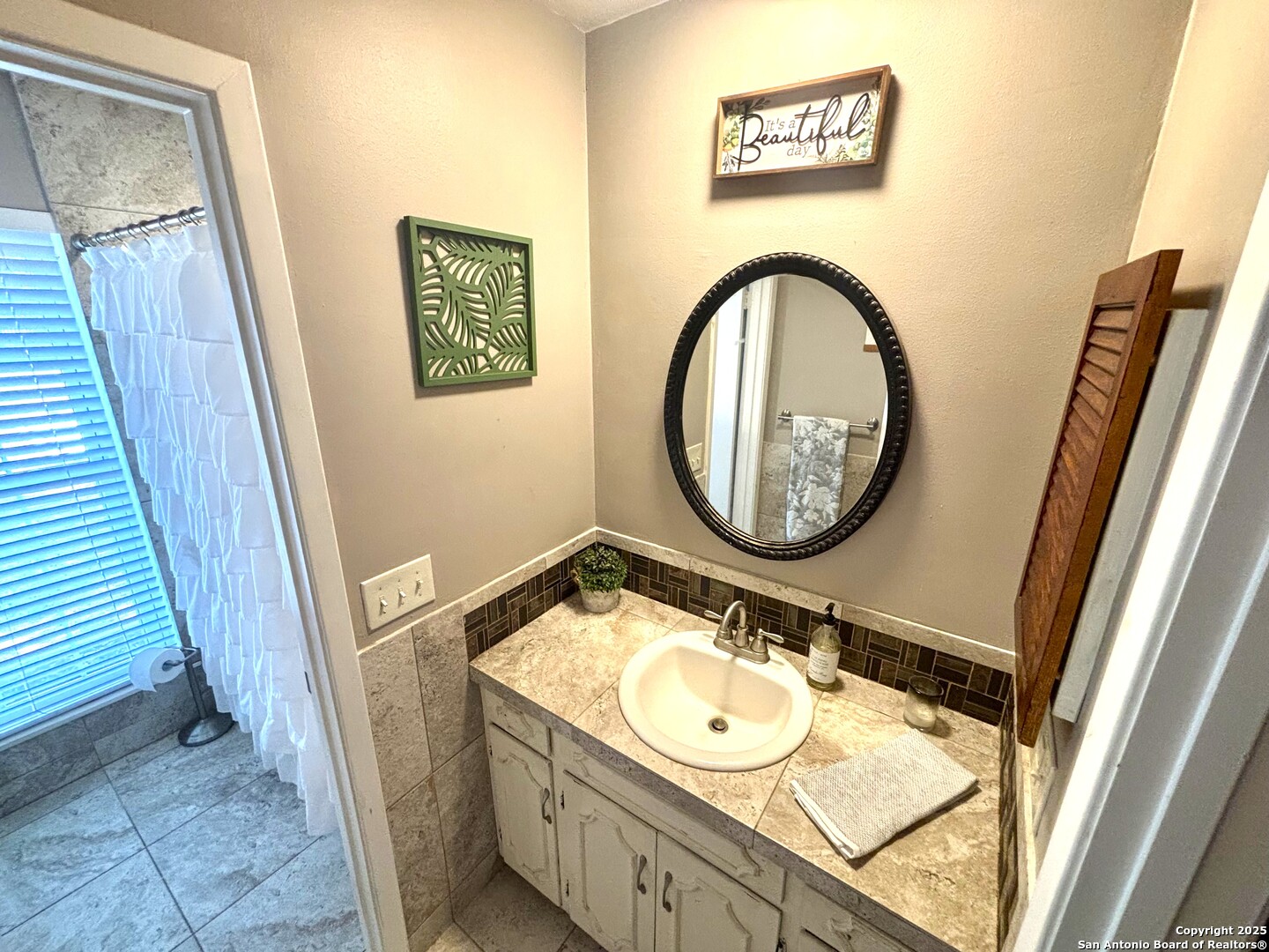 175 Columbus Street McDade, TX 78650 - Photo 17 of 23 a bathroom with a granite countertop sink and a mirror