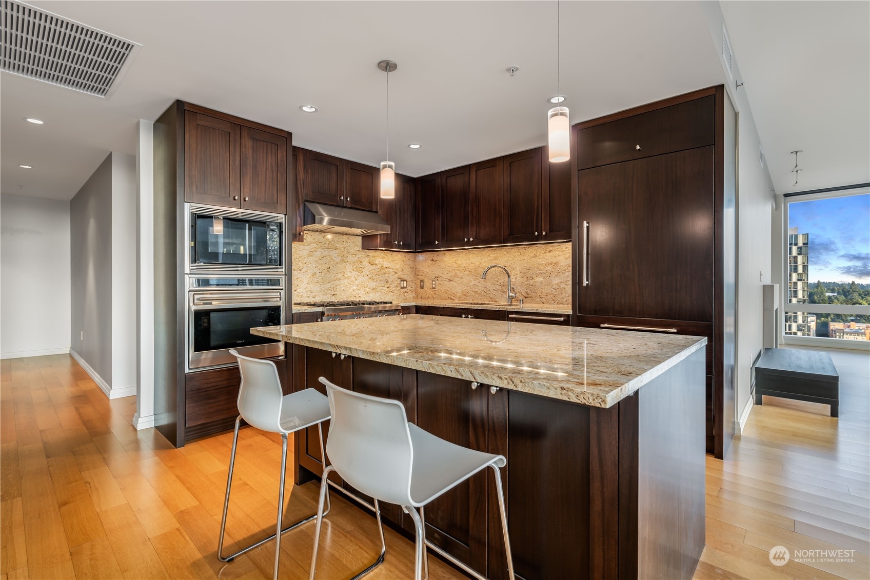 a kitchen with granite countertop kitchen island wooden cabinets and stainless steel appliances