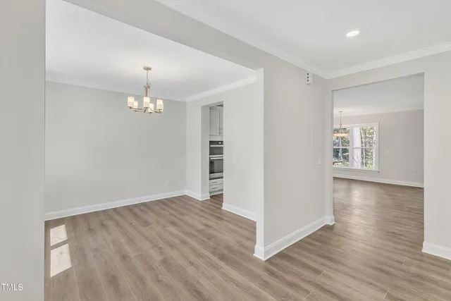 a kitchen with granite countertop a stove a sink and white cabinets with wooden floor