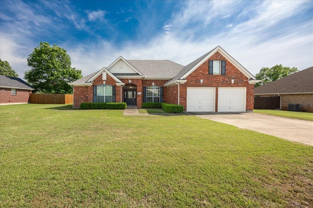 View of front of house featuring fence, central AC, brick siding, a garage, and driveway