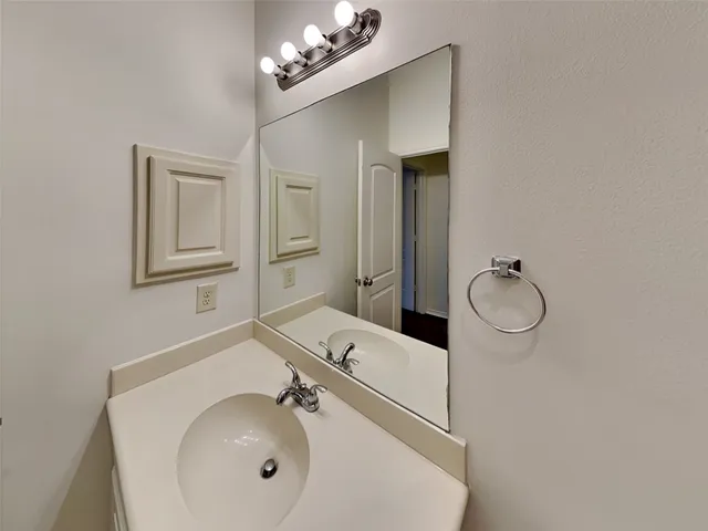 a bathroom with a sink mirror and vanity