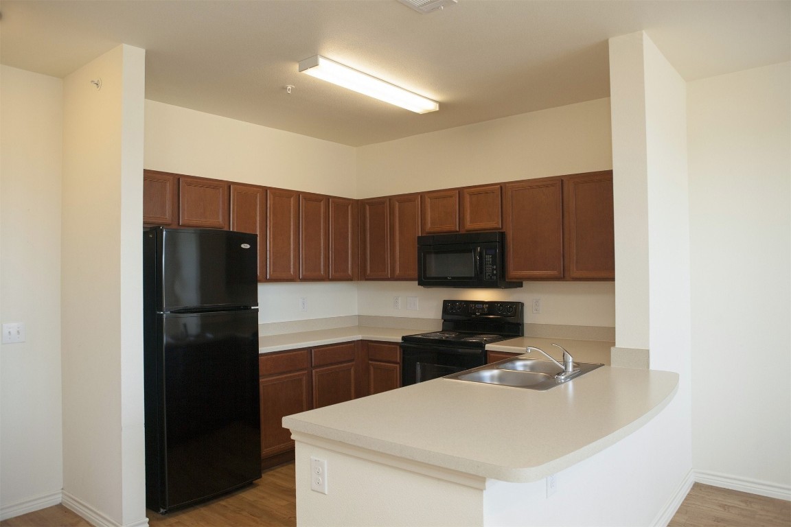5121 North Foster Road San Antonio, TX 78244 - Photo 9 of 10 a kitchen with a refrigerator a stove a microwave and cabinets