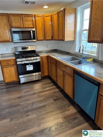 a kitchen with stainless steel appliances a stove sink and microwave