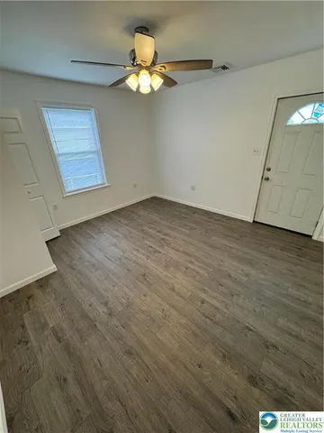an empty room with wooden floor and window