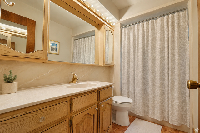 2924 Robidoux Road Sandy, UT 84093 - Photo 40 of 68 Vanity with wood-finish cabinetry, integrated sink, and light-colored countertop