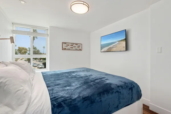 a bedroom with a bed and a painting on the wall