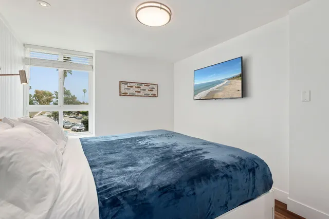 a bedroom with a bed and a painting on the wall