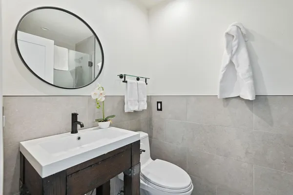 a bathroom with a sink a toilet and a mirror