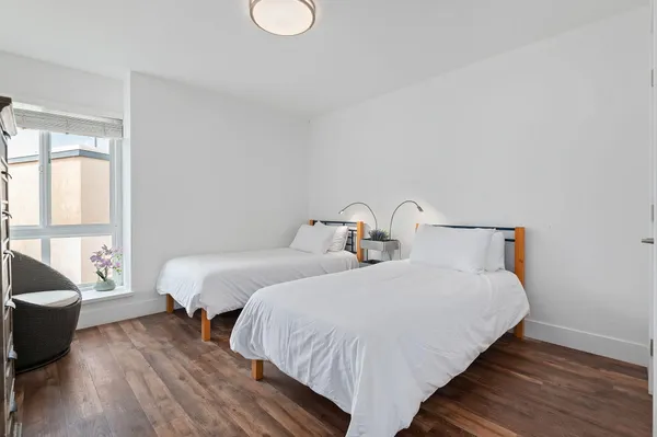a bedroom with two beds and wooden floor