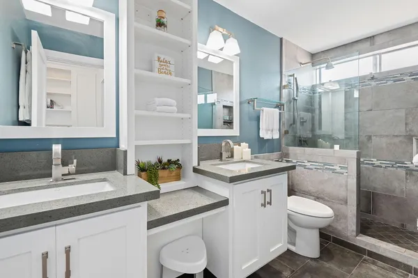 a bathroom with a granite countertop toilet sink and a mirror