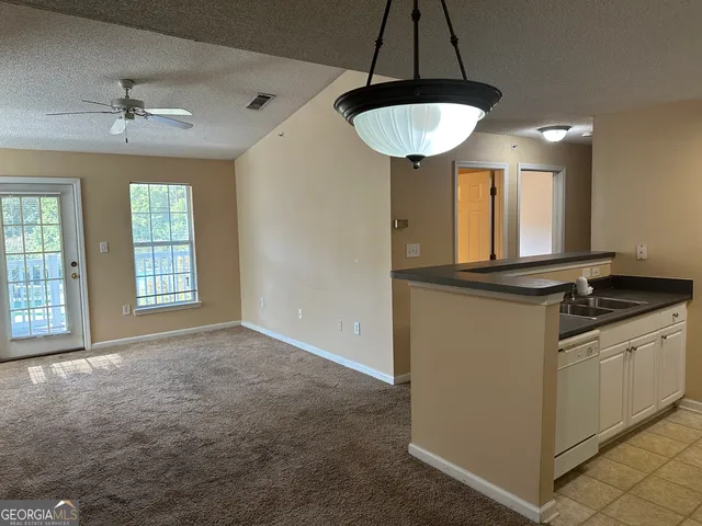 a kitchen with stainless steel appliances granite countertop a sink a stove and a window