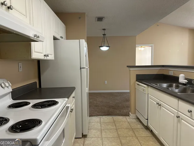 a kitchen with a sink stove and refrigerator