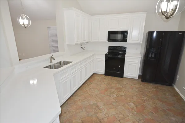 a view of a kitchen with a sink and a refrigerator