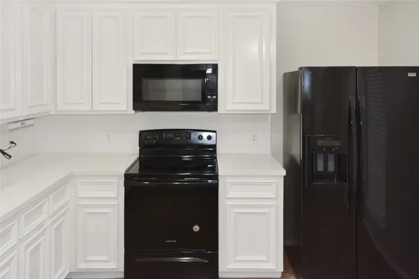 a kitchen with a refrigerator and cabinets