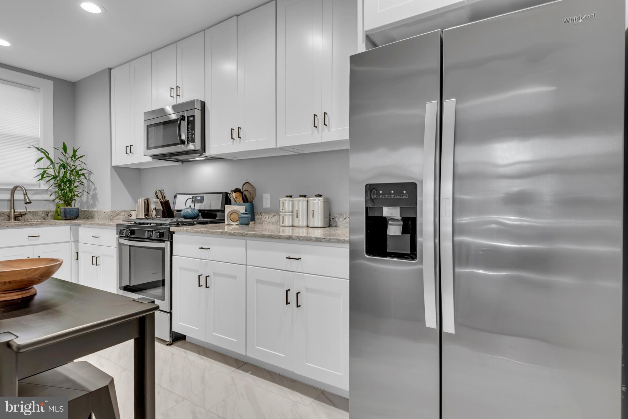 3020 Porter Street Northwest, Unit 103 Washington, DC 20008 - Photo 13 of 30 a kitchen with cabinets and a refrigerator