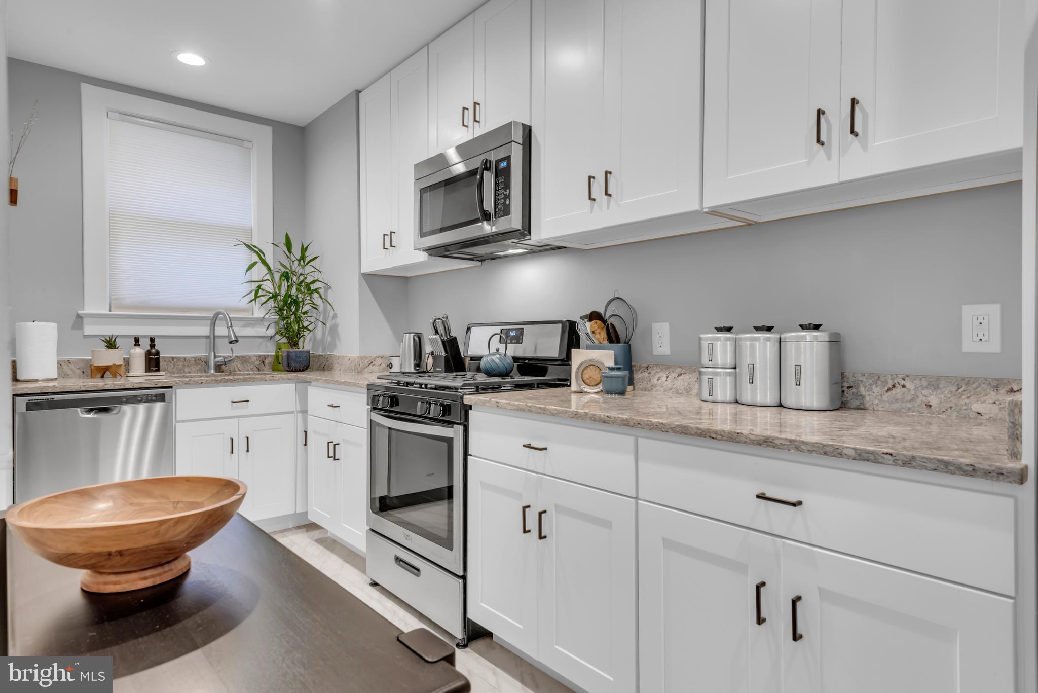 3020 Porter Street Northwest, Unit 103 Washington, DC 20008 - Photo 14 of 30 a kitchen with white cabinets stainless steel appliances and sink